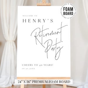 Puede incluir: Un letrero de espuma blanco con texto negro, exhibido en un caballete de madera. El letrero dice "Bienvenido a la fiesta de jubilaci&oacute;n de Henry" en una elegante escritura. Tambi&eacute;n incluye "&iexcl;Salud por 40 a&ntilde;os!" y la fecha. El letrero mide 61 cm x 91 cm.