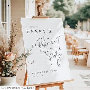 Puede incluir: Un letrero de espuma blanco sobre un caballete de madera, con el texto "WELCOME TO HENRY'S Retirement Party" en escritura negra. El letrero mide 61 x 91 cm e incluye el texto "CHEERS TO 40 YEARS!" y la fecha 06.30.20XX.