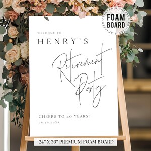 Puede incluir: Un letrero de espuma blanco sobre un caballete, con las palabras "Welcome to Henry's Retirement Party" en escritura negra. El letrero mide 61 x 91 cm e incluye el texto "Cheers to 40 Years!" y una fecha. El letrero est&aacute; rodeado de arreglos florales.