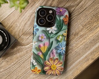 Puede incluir: Una funda de teléfono con un diseño floral que presenta flores de papel en tonos azules, rosas, amarillos y verdes. Las flores están dispuestas en un patrón sobre un fondo azul claro.