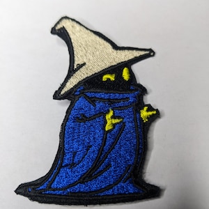 May include: An embroidered patch of a blue wizard with a white pointed hat and yellow eyes. The wizard is wearing a blue robe with yellow accents.