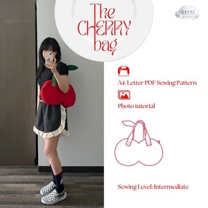 Puede incluir: Una bolsa roja con forma de cereza con un tallo y una hoja verdes. La bolsa está hecha de tela y tiene una cremallera. La bolsa está siendo modelada por una persona que lleva un vestido blanco y negro. La imagen también incluye texto que dice "The CHERRY bag", "A4/Letter PDF Sewing Pattern", "Photo tutorial", y "Sewing Level: Intermediate".