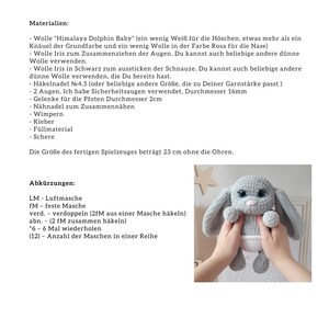 May include: A gray crocheted bunny with pink ears and blue eyes. The bunny is wearing a white diaper and is 23 inches tall without the ears.