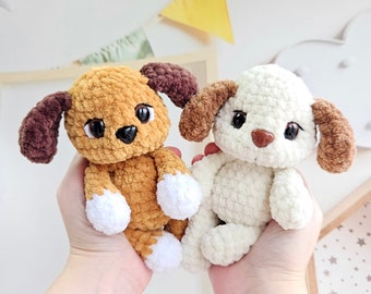 以下が含まれることがあります： 2つの毛糸で編まれた犬のぬいぐるみ。1つは茶色と白、もう1つは白。どちらも黒い目と茶色の鼻をしています。