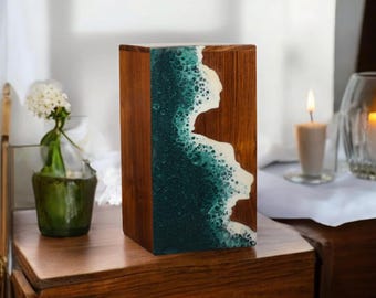 May include: A wooden box with a teal and white resin inlay. The resin has a wave-like pattern with white foam and teal water.