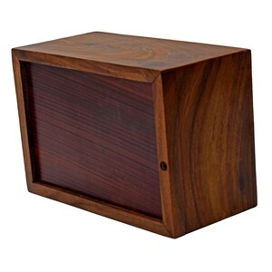 Puede incluir: Una caja de madera con un interior rojo oscuro. La caja est&aacute; hecha de madera maciza y tiene un acabado natural.