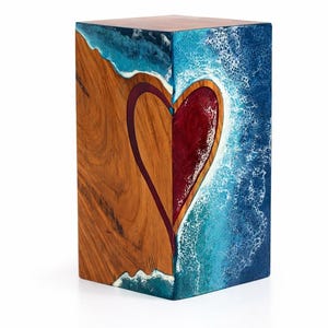 May include: A wooden block with a heart design. One side features natural wood grain, the other a blue and white ocean-like resin. The heart is red with a dark purple outline. The top is a dark brown color.