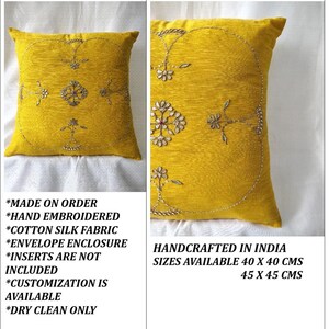 May include: A square, yellow decorative pillow with hand-embroidered floral designs. The pillow is made of cotton silk fabric and has an envelope enclosure. Available sizes are 40 x 40 cm and 45 x 45 cm.
