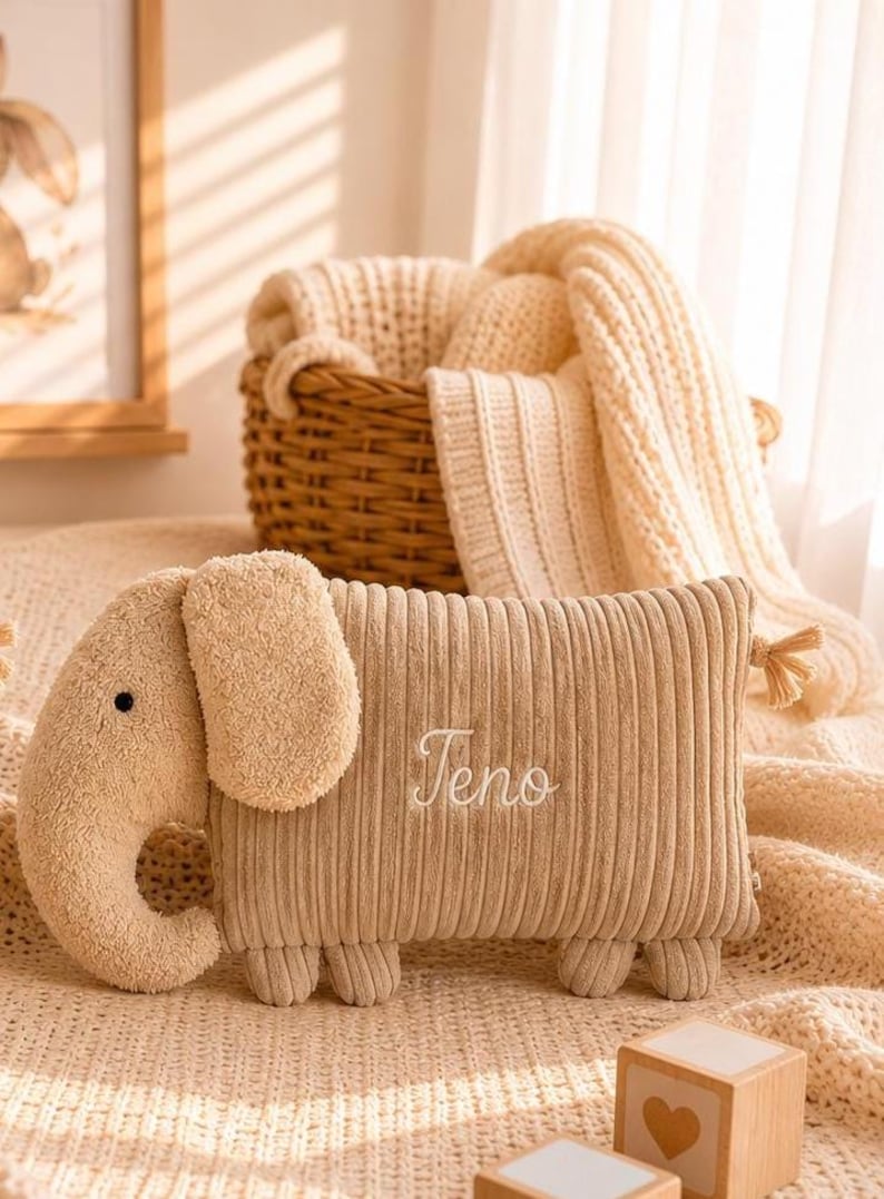 Peut inclure: Une peluche en velours c&ocirc;tel&eacute; beige en forme d'&eacute;l&eacute;phant avec une t&ecirc;te et une trompe textur&eacute;es. Le corps rectangulaire porte le pr&eacute;nom brod&eacute; "Teno" en &eacute;criture blanche. Le jouet poss&egrave;de de petites pattes arrondies et un pompon d&eacute;coratif.