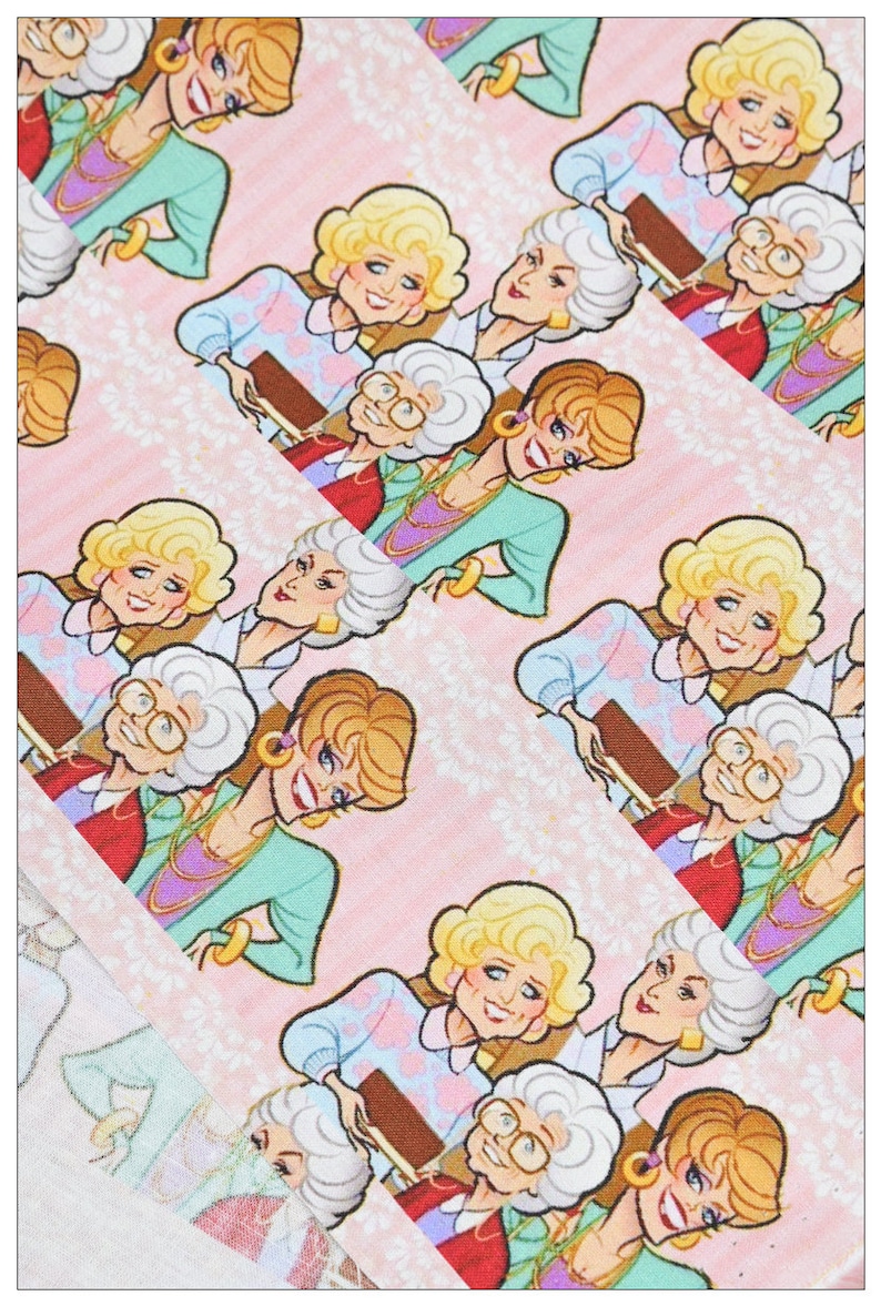 May include: A pink and white patterned fabric with a repeating design of four cartoon women. The women are wearing colorful outfits and have different hairstyles. The fabric is perfect for crafting projects, such as making bags, pillows, or quilts.