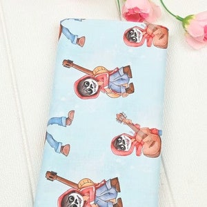May include: Blue fabric with a repeating pattern of a cartoon character playing a guitar. The character is wearing a red hooded jacket and has a skeleton face.