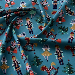 May include: Teal fabric featuring a repeating pattern of festive illustrations. The design includes nutcrackers, mice in regal attire, Christmas trees, rocking horses, and dancing figures. Ideal for holiday-themed crafts and projects.