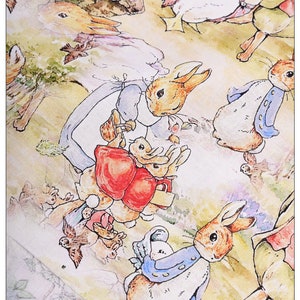 May include: A white fabric with a repeating pattern of watercolor illustrations of bunnies and a duck. The bunnies are wearing blue and white clothing and carrying other bunnies. The duck is wearing a pink and white dress.