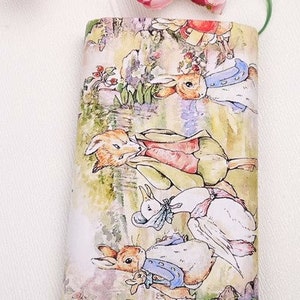 May include: A white fabric with a colorful illustration of Peter Rabbit and friends. The illustration features a fox, a rabbit, a duck, and a goose. The fabric is perfect for crafting projects, such as quilting, sewing, and scrapbooking.