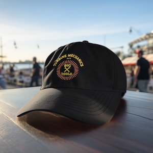 Puede incluir: Gorra de béisbol negra con un logotipo bordado en amarillo y naranja que dice "Turbine Mechanics Big Tools".