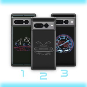 Puede incluir: Tres fundas para teléfono con diferentes diseños inspirados en la película Regreso al futuro. La primera funda presenta un dibujo lineal de los zapatos autoajustables de Marty McFly. La segunda funda presenta un dibujo lineal del DeLorean con el texto "DELOREAN DMC-12". La tercera funda presenta un reloj azul y rojo neón con el texto "REGRESO AL FUTURO" y un dibujo lineal del DeLorean.