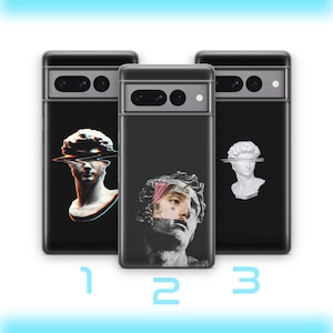 Può includere: Tre custodie per telefono nere con design diversi. La prima custodia presenta una scultura di busto bianco con un effetto glitch. La seconda custodia presenta una scultura di busto in bianco e nero con un ritratto di una persona con tatuaggi e un fiore rosa nei capelli. La terza custodia presenta una scultura di busto bianco con una linea orizzontale sugli occhi.