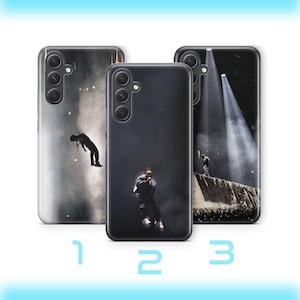 Peut inclure: Trois étuis de téléphone différents avec des designs variés. Le premier étui présente une image en noir et blanc d'une personne dans un décor sombre. Le deuxième étui présente une image en noir et blanc d'une personne dans un décor sombre. Le troisième étui présente une image en noir et blanc d'une personne dans un décor sombre avec un projecteur qui l'éclaire.