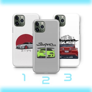 Puede incluir: Tres fundas de teléfono diferentes con un Toyota Supra rojo, verde y blanco. Las fundas son blancas con un contorno negro y el texto "Supra" en negro. La primera funda presenta un Supra rojo con el texto "Supra" en japonés. La segunda funda presenta un Supra verde con el texto "Supra" en japonés. La tercera funda presenta un Supra blanco con el texto "Supra" en japonés.