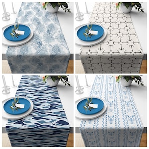 May include: A collection of four rectangular table runners featuring distinct nautical patterns including blue seahorses and seashells, black anchors, blue ocean waves, and light blue lobsters on a white background with a blue plate.