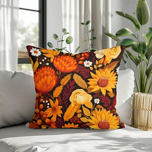 Op de afbeelding: Een vierkant sierkussen met een dicht, levendig bloemenpatroon op een zwarte achtergrond. Het ontwerp bevat grote oranje protea-achtige bloemen, felgele zonnebloemen, lichtgele rozen en kleine witte madeliefjes met groen blad.
