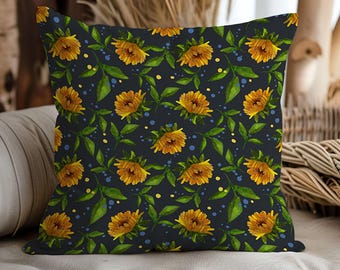 May include: Square throw pillow with a floral pattern. The design features yellow sunflowers, green leaves, and blue accents on a dark navy background. The pillow is a decorative home accent.