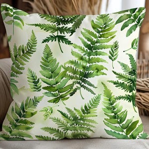 May include: Square decorative pillow with a watercolor fern leaf pattern. The pillow features a light background with a repeating pattern of green fern leaves. The pillow is a square shape and appears to be made of a soft fabric.