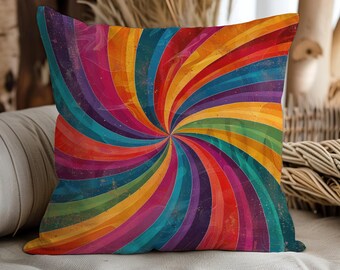 Puede incluir: Cojín cuadrado con un diseño en espiral vibrante y colorido. El cojín presenta un espectro de colores que incluye rojo, naranja, amarillo, verde, azul y morado. El diseño recuerda a un arcoíris o un patrón psicodélico.