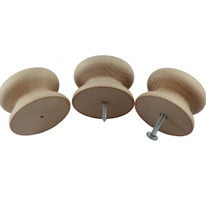 May include: Three unfinished wooden knobs with a screw hole in the centre. The knobs are round and have a slightly raised centre. The screws are included.