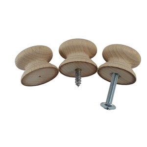 May include: Three wooden knobs with a silver screw. The knobs are light brown and have a rounded shape.