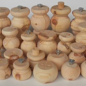 May include: A collection of 20 unfinished wooden furniture legs with a turned design. The legs are various sizes and have a natural wood colour.