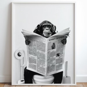 Puede incluir: Impresión en blanco y negro enmarcada que presenta a un chimpancé leyendo un periódico titulado "MONKEY BUSINESS" mientras está sentado en un inodoro. El chimpancé está fumando un cigarro. También se ve un rollo de papel higiénico y un cepillo.