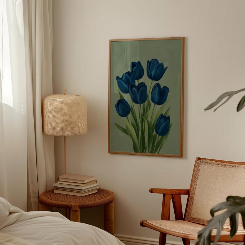 May include: A framed art print featuring a bouquet of blue tulips against a muted green background. The artwork is displayed in a room with a neutral color palette, including a woven side table, a lamp, and a chair.