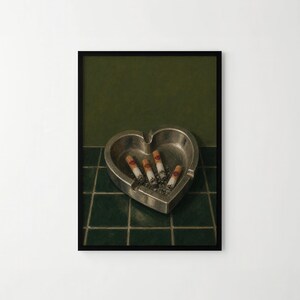 May include: A heart-shaped silver metal ashtray containing four cigarette butts, each featuring a small red lipstick kiss mark on the filter. The ashtray is positioned on a dark green tiled surface against a solid dark green background.
