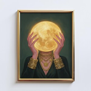 May include: A framed art print featuring a woman holding a glowing yellow moon in front of her face. She wears gold jewelry, including necklaces and bracelets. The background is a dark green, and the frame is gold.