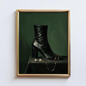 May include: A framed art print featuring a black leather boot with a block heel, a gold chain, and a pair of pearl earrings. The artwork is set against a dark green backdrop, creating a classic and elegant aesthetic.