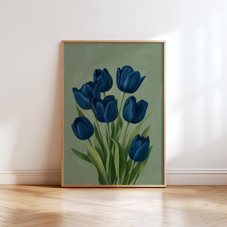 May include: A framed art print featuring a bouquet of deep blue tulips against a muted green background. The flowers have detailed petals and green leaves. The frame is a light gold color, and the artwork is displayed on a white wall above a wooden floor.