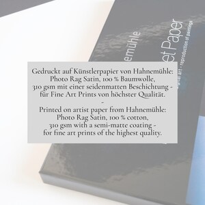 May include: A stack of white and dark gray paper sheets featuring text that reads: Printed on artist paper from Hahnem&uuml;hle: Photo Rag Satin, 100% cotton, 310 gsm with a semi-matte coating - for fine art prints of the highest quality.