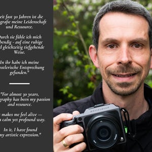 May include: A person holding a dark gray Hasselblad camera. To the left, a black panel features white text in German and English: "Seit fast 30 Jahren ist die Fotografie meine Leidenschaft und Ressource... For almost 30 years, photography has been my passion and resource."