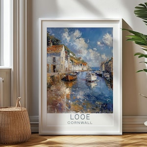 May include: A painting of a harbor scene in Looe, Cornwall. The painting features a small town with colorful buildings and boats in the water. The sky is blue with white clouds. The painting is framed in white.