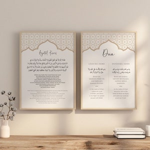 Könnte beinhalten: Zwei gerahmte Drucke mit islamischer Kalligraphie und geometrischen Mustern. Der linke Druck zeigt den Ayatul Kursi, einen Vers aus dem Koran, und der rechte Druck zeigt eine Dua, oder ein Gebet, zum Verlassen und Betreten des Hauses.