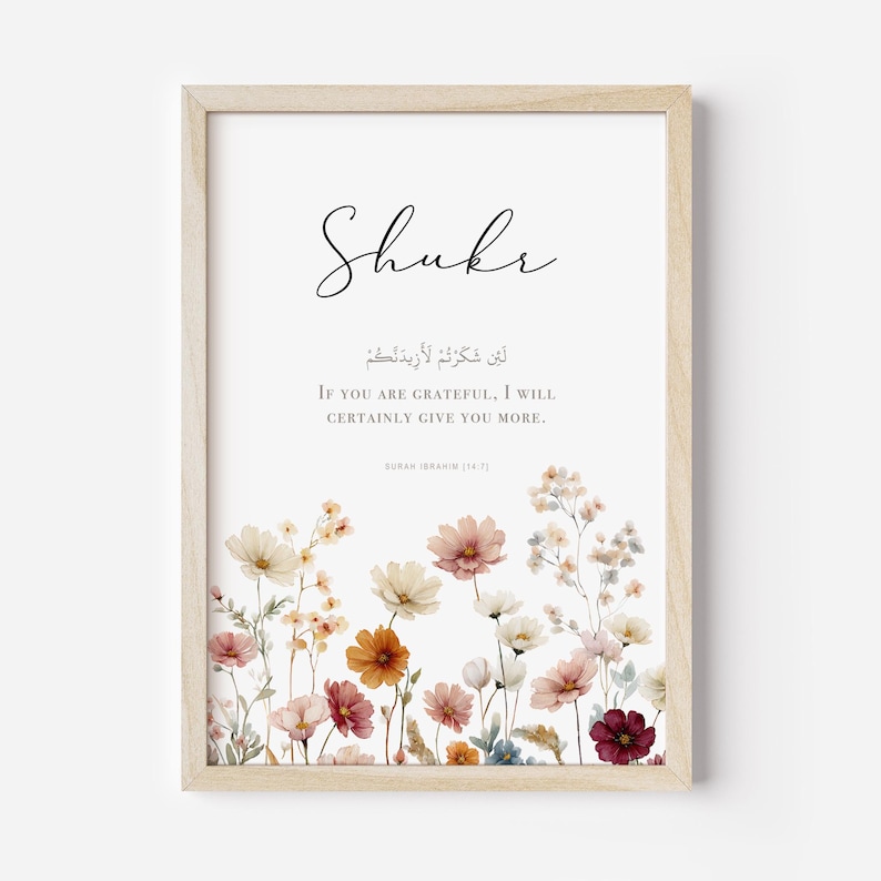 May include: A framed art print with the word "Shukr" in elegant script. Below, Arabic text and the English translation: "If you are grateful, I will certainly give you more." The bottom features a watercolor floral border in soft colors.