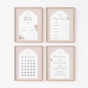 May include: Four framed art prints with a beige background and wooden frames. The prints feature Islamic-themed designs with floral accents and the words "Ramadan Mubarak," "Prayer Times," "Ramadan Calendar," and "Ramadan Duas."