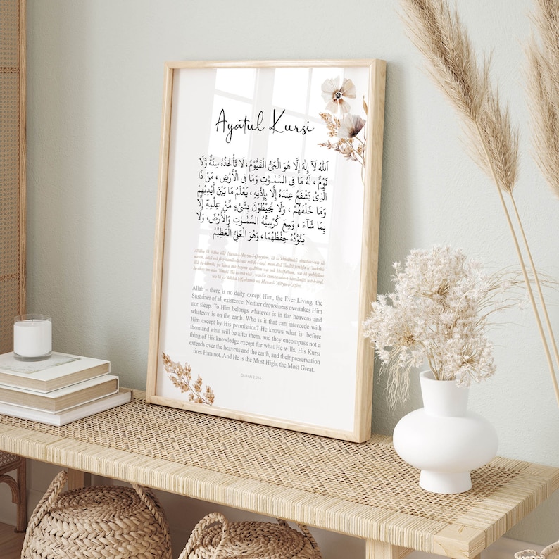 Puede incluir: Una impresi&oacute;n enmarcada beige con el texto &aacute;rabe "Ayatul Kursi" y una traducci&oacute;n al ingl&eacute;s. La impresi&oacute;n presenta un dise&ntilde;o floral con flores marrones y blancas.