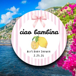 May include: A round baby shower invitation with a pink bow and pink striped background. The text "ciao bambina" is written in black script. Below the text is a watercolor illustration of lemons. The text "Ali's Baby Shower 2.25.26" is also included.