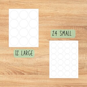 May include: Two sheets of white, round stickers are displayed on a wooden surface. One sheet contains 12 large stickers, and the other has 24 small stickers. The text "12 LARGE" and "24 SMALL" are written on green rectangles.