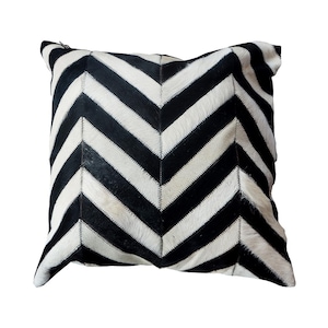 May include: Black and white chevron patterned throw pillow made from cowhide.