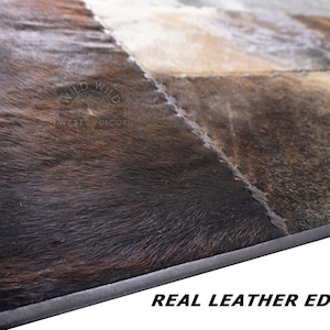 A patchwork cowhide rug with brown, black, and white patches.