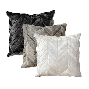 Peut inclure: Trois coussins décoratifs avec un motif en chevron. Les coussins sont faits d'un tissu doux et texturé et sont disponibles en noir, gris et blanc.