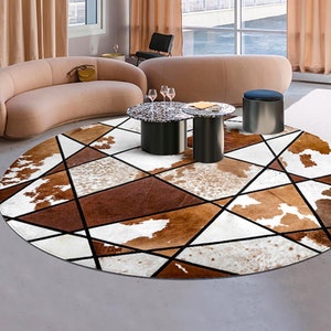 May include: A round, white, brown, and black area rug with a geometric pattern. The rug is made of cowhide and has a modern design. The rug is in a living room setting with a sofa and two coffee tables.